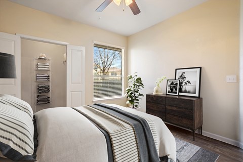 A bedroom with a bed, dresser, and window.
